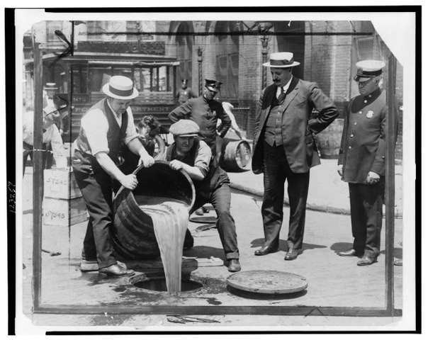 New York City Deputy Police Commissioner John A. Leach, right, watching agents pour liquor into sewer following a raid during the height of prohibition. Photo in Public domain, via Wikimedia Commons 